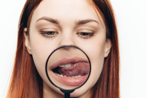 pretty woman grimacing with magnifying glass near face close-up - Foto, imagen