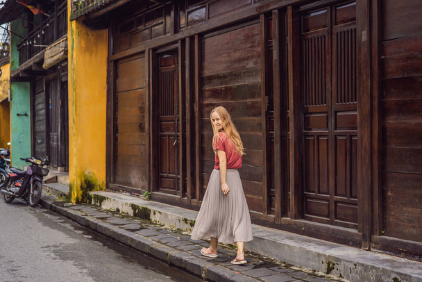 Woman tourist on background of Hoi An ancient town, Vietnam. Vietnam opens to tourists again after quarantine Coronovirus COVID 19 - 写真・画像