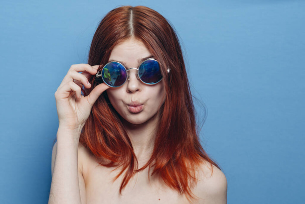 perky red-haired woman in blue glasses bare shoulders posing - Fotografie, Obrázek