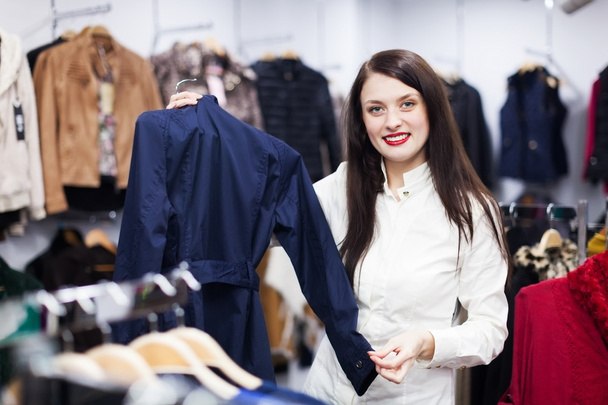 woman choosing jacket at boutique - 写真・画像