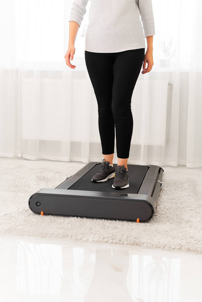 Sporty woman using walking treadmill on white background - Fotografie, Obrázek