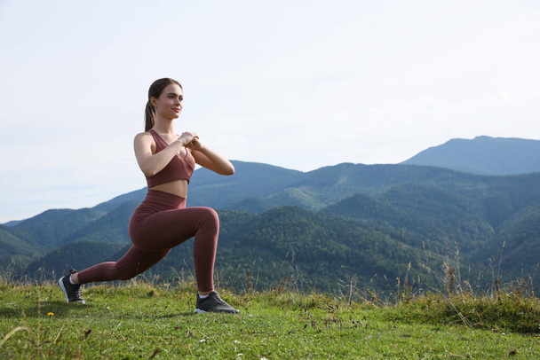 Young woman doing morning exercise in mountains, space for text - Fotografie, Obrázek