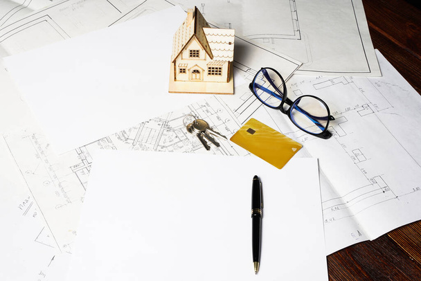 Modell eines Hauses und Schlüsselanhängers, Planprojekt und Zeichnungen auf Papier mit Kopierraum - Foto, Bild