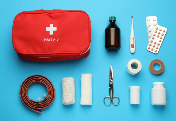 Flat lay composition with first aid kit on light blue background - Foto, imagen
