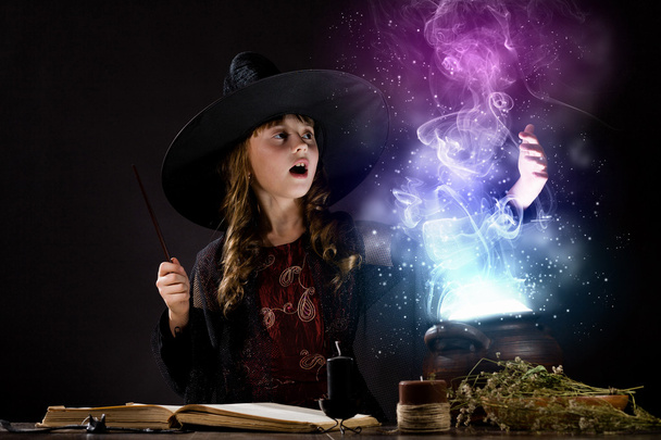 Pequeña bruja leyendo conjuros
 - Foto, Imagen