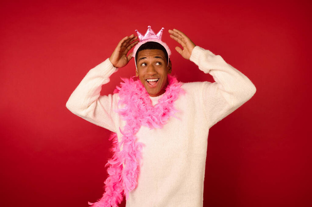 A dark-skinned young ma in a crown and with a pink garland - Foto, Imagem