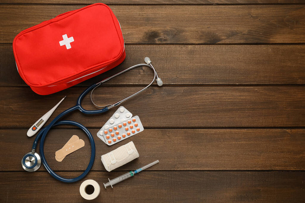 First aid kit on wooden table, flat lay. Space for text - Fotó, kép