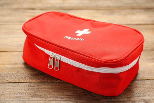 First aid kit bag on wooden table, closeup. Health care - Foto, afbeelding