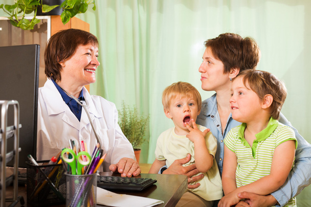 Mother of two children  talking with friendly  doctor - Foto, imagen