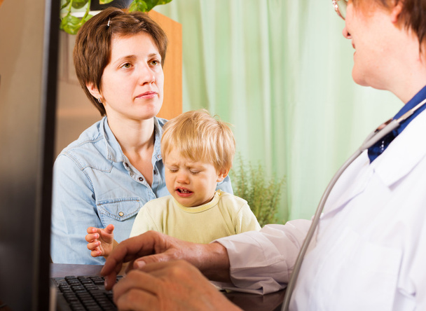 Woman with baby listening   doctor at clinic - Foto, Bild