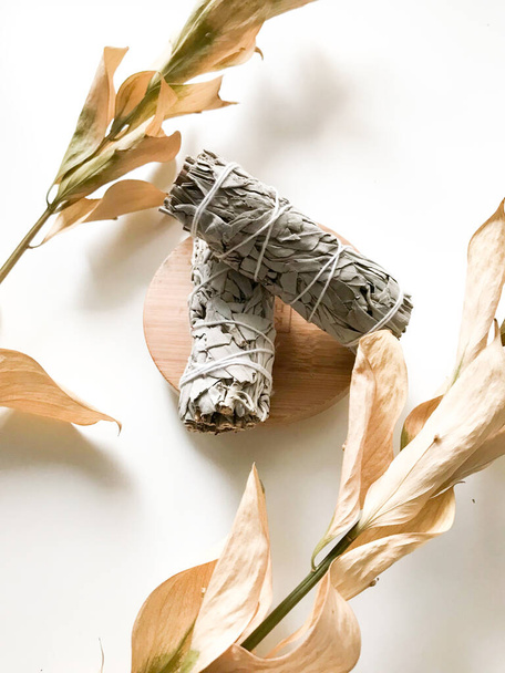 bunches of white California sage on a white background, minimalism and a place for text. sacred incense, aromatherapy and meditation - Фото, изображение