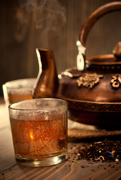 Старый чугунный чайник горячий чай на темном деревянном фоне
 - Фото, изображение