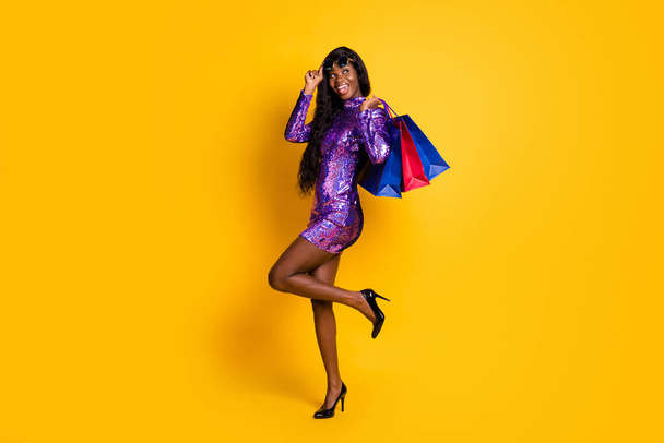 Full length body size photo of sexy black skinned woman keeping bags after shopping isolated vibrant yellow color background - Valokuva, kuva
