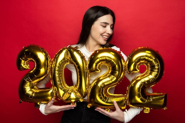 Młoda radosna kobieta trzyma numery 2022. Nadchodzące święta - Zdjęcie, obraz