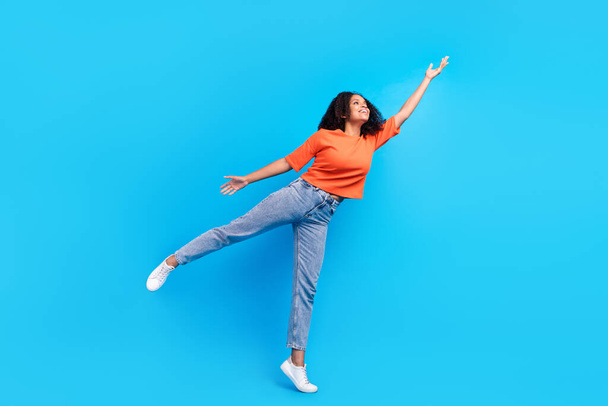 Full length photo of dreamy happy joyful afro american young woman hand empty space isolated on blue color background - Fotografie, Obrázek