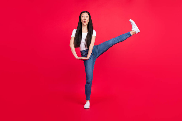 Full length photo of young attractive asian girl amazed shocked surprised fooling legs isolated over red color background - Фото, зображення