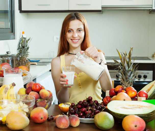 Женщина наливает молочный коктейль с фруктами
 - Фото, изображение