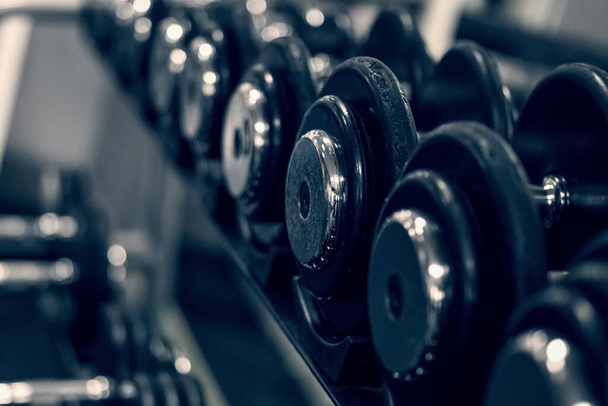 A rack with dumbbells in the gym or fitness club. Doing sports and fitness. Bodybuilding. - Foto, Imagen