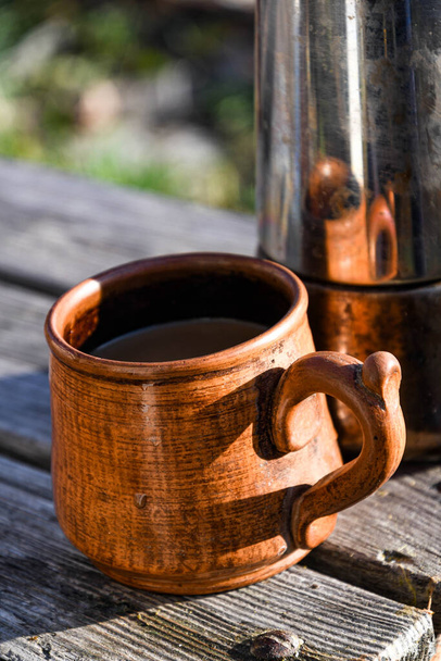 Керамічна чашка з кавою на вулиці в саду, приготована в гейзерній кавоварці
. - Фото, зображення