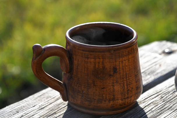 Ceramic cup with coffee outside in the garden prepared in a geyser coffee maker. - Photo, Image