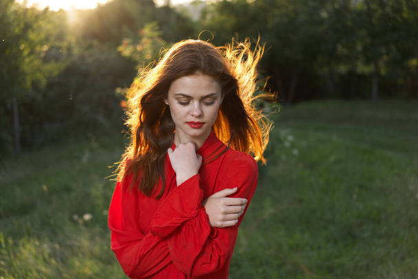 cheerful woman in a red dress in a field outdoors fresh air - Foto, Imagem