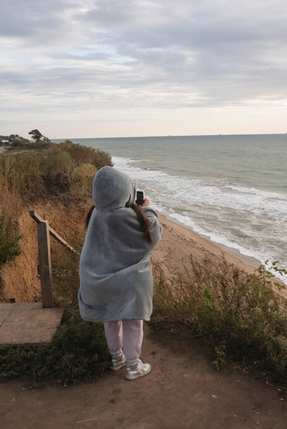 Young woman on cold autumn seashore posing at camera - Foto, immagini