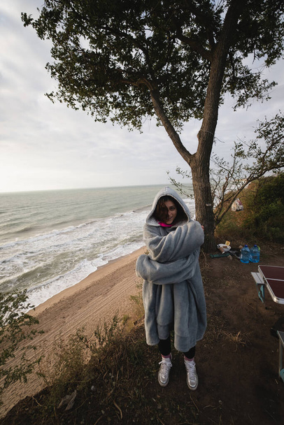 Young woman on cold autumn seashore posing at camera - Фото, изображение
