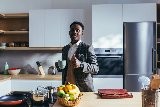 Afroamerykanin biznesmen będzie pracował w domu, jadł śniadanie w kuchni, rozmawiał przez telefon - Zdjęcie, obraz