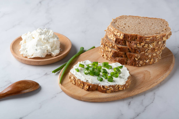 Pão de centeio no prato com queijo coalhado e cebola verde. Alimentos saudáveis - Foto, Imagem