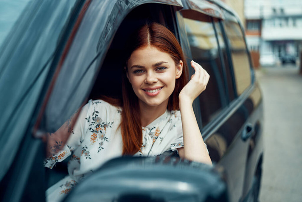 cheerful woman driving a car looks out of the window - Foto, Imagen