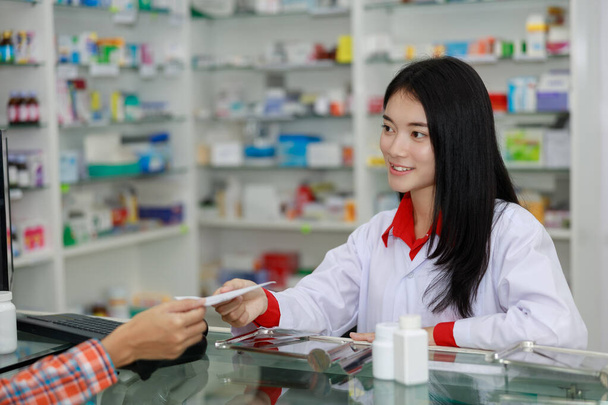 Asian Woman Pharmacist selling medications in the pharmacy store thailand - Zdjęcie, obraz