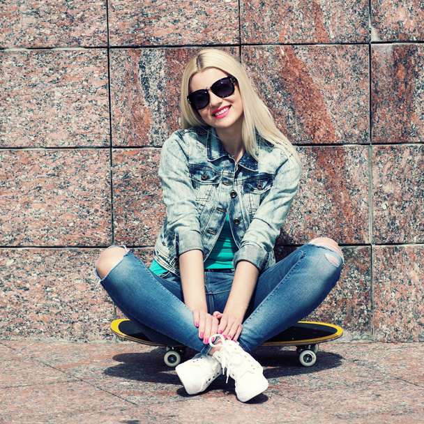 ジャケット、スケート ボード上に座っている女の子 - 写真・画像