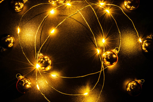 Des lumières de Noël. Décoration d'ornement de fête de Noël avec décoration de guirlande de lumière dorée, ampoule en or isolée sur fond noir. Noël, hiver, nouvelle année concept. - Photo, image
