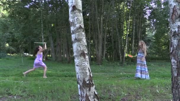 Mujer embarazada con hija niña jugar juego de bádminton en el parque
 - Metraje, vídeo