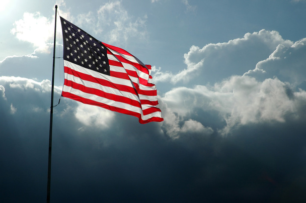 嵐の空に対してアメリカの国旗 - 写真・画像