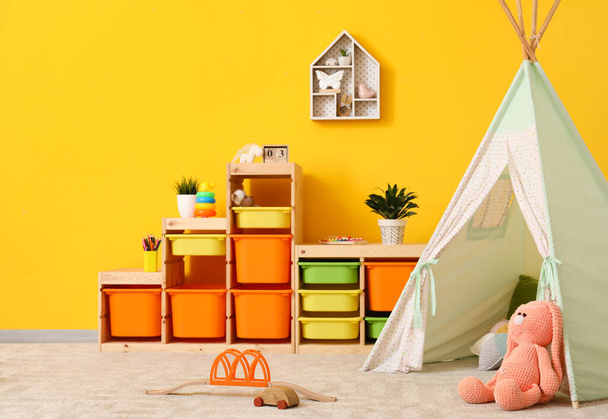 Стильний інтер'єр сучасної дитячої кімнати з ігровим наметом
 - Фото, зображення