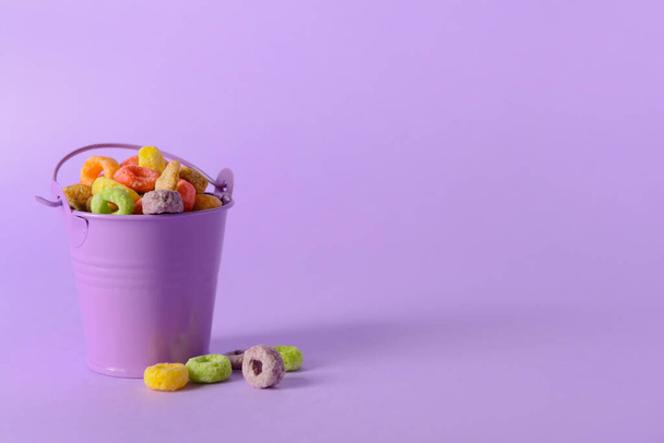 Pequeno balde com flocos de milho crocante anéis no fundo de cor - Foto, Imagem