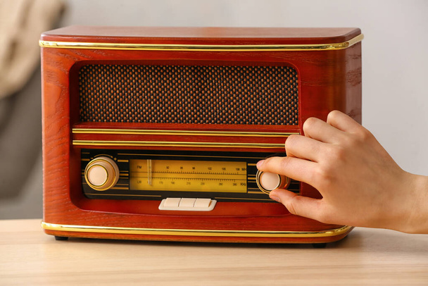 Woman switching on the radio at home - 写真・画像