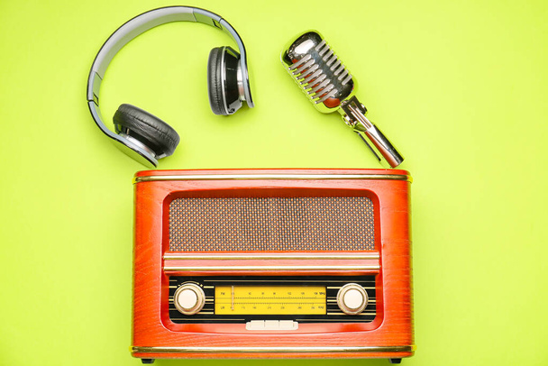 Receptor de radio retro con micrófono y auriculares sobre fondo de color - Foto, imagen