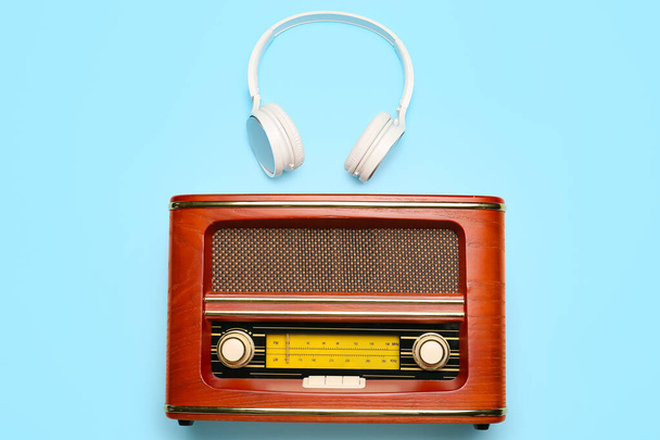 Odbiornik radiowy Retro ze słuchawkami na tle koloru - Zdjęcie, obraz