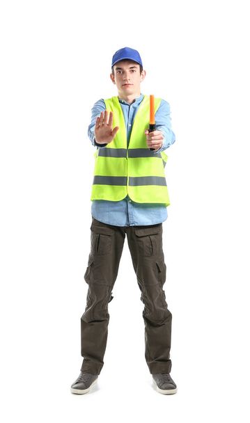 Νεαρός εργάτης με φακό που δείχνει χειρονομία stop σε λευκό φόντο - Φωτογραφία, εικόνα