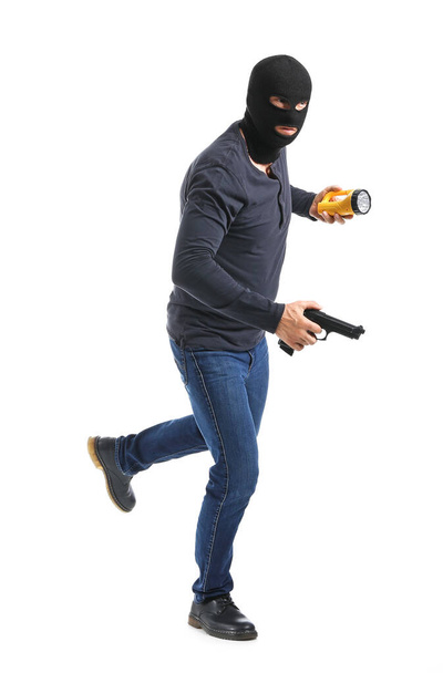 Hombre criminal con linterna y pistola sobre fondo blanco - Foto, imagen