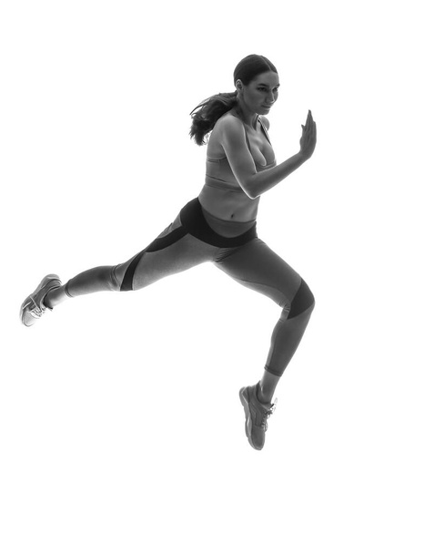Silhouette of sporty running woman on white background - Фото, зображення