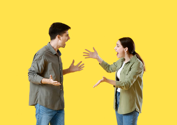 Молодая пара ссорится на жёлтом фоне - Фото, изображение