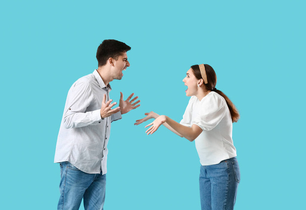 Joven pareja peleando sobre fondo azul - Foto, Imagen