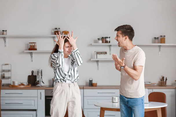 Rozzlobený mladý muž křičí na svou ženu v kuchyni - Fotografie, Obrázek