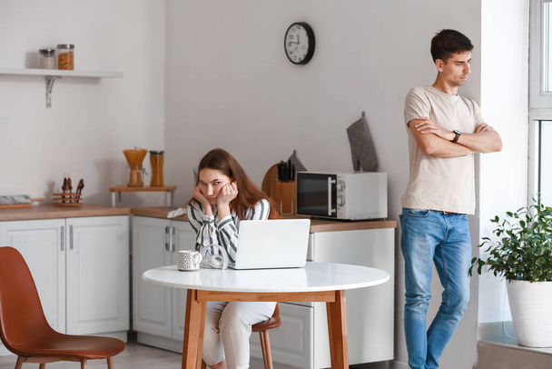 Zdenerwowana młoda kobieta i jej chłopak po kłótni w kuchni - Zdjęcie, obraz