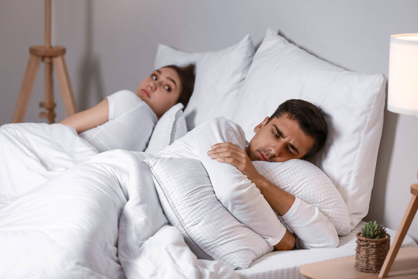 verontwaardigde jongeman liggend in bed na ruzie met zijn vrouw - Foto, afbeelding