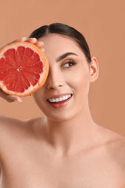 Happy woman with grapefruit on color background - Photo, Image