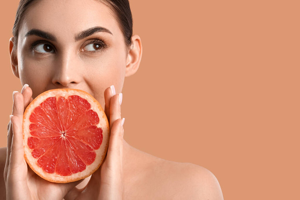 Vrouw met grapefruit op kleur achtergrond - Foto, afbeelding